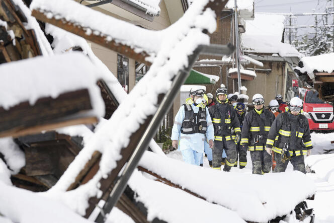 Des pompiers fouillent, sous la neige, les maisons tombées dans la ville japonaise de Suzu lors du tremblement de terre du Nouvel An, lundi 8 janvier 2024. 