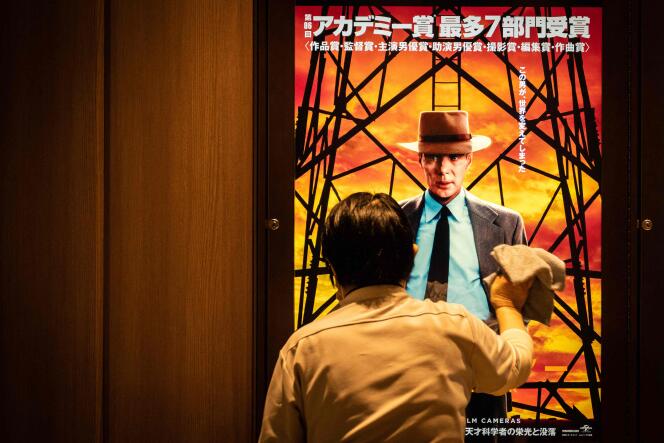 Un ouvrier nettoie un écran montrant une publicité pour « Oppenheimer » à Tokyo, le 29 mars 2024, jour de la sortie du film dans les salles japonaises.

