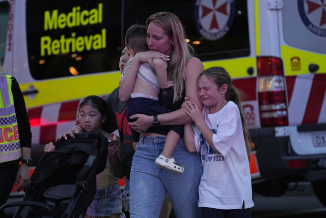 Des personnes sont conduites hors du centre commercial Westfield Bondi Junction, où plusieurs personnes ont été poignardées, à Sydney (Australie), le samedi 13 avril 2024. 