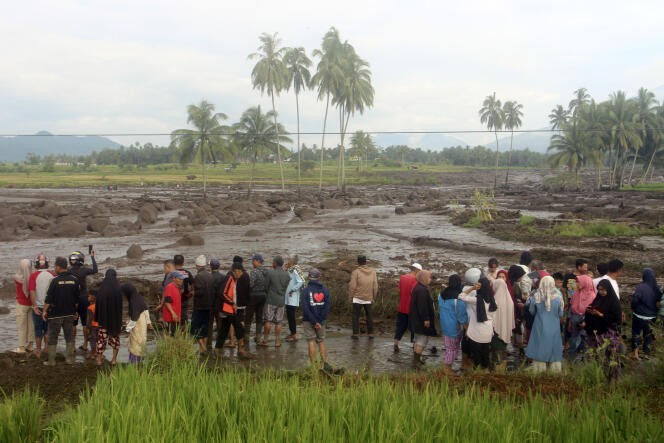 Des personnes inspectent une zone affectée par la crue soudaine qui a tué plusieurs personnes à Agam, Sumatra occidental, Indonésie, dimanche 12 mai 2024. 