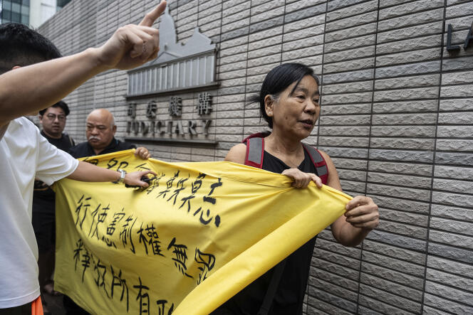 Des membres de la Ligue des sociaux-démocrates tiennent une banderole devant le tribunal de première instance de West Kowloon à Hongkong, le 30 mai 2024, avant les verdicts dans l’affaire de la sécurité nationale.