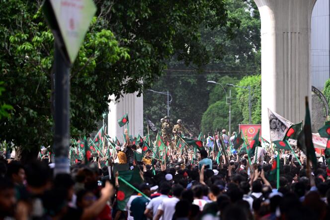 Des manifestants contre le gouvernement marchent vers le palais de la première ministre du Bangladesh, Sheikh Hasina, tandis que des militaires montent la garde dans la région de Shahbag, près de l’université de Dacca, le 5 août 2024.