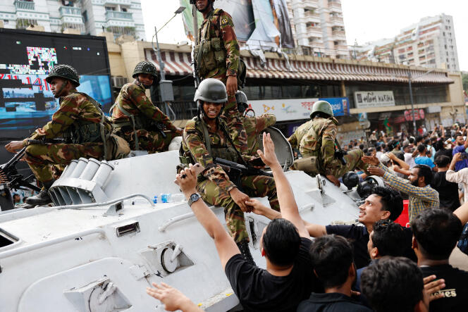 Des manifestants saluent des membres de l’armée à Dacca, après l’annonce de la démission de la première ministre, Sheikh Hasina, le 5 août 2024.