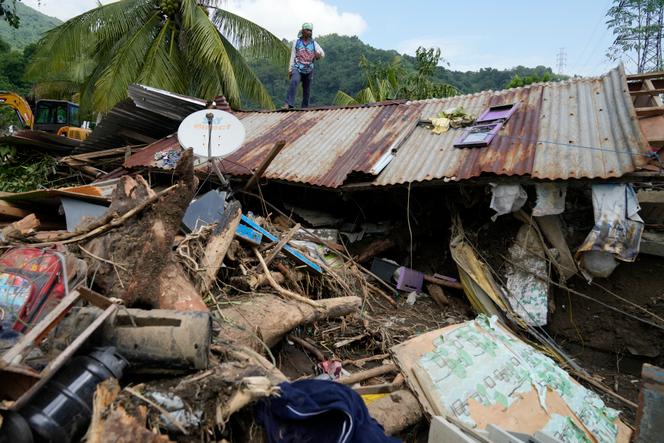 Marcelino Aringo stands over a damaged house after a landslide triggered by tropical storm Trami that recently hit Talisay, Philippines, Saturday, October 26, 2024. 