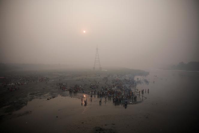 Hindu worshipers worship the sun god in the polluted waters of the Yamuna River during the Hindu religious festival of Chhath Puja on a smoggy morning in New Delhi on November 8, 2024.