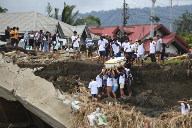 A coffin is carried on a riverbank damaged by heavy rains caused by Typhoon Trami, in Laurel town, Batangas province, October 30, 2024. 