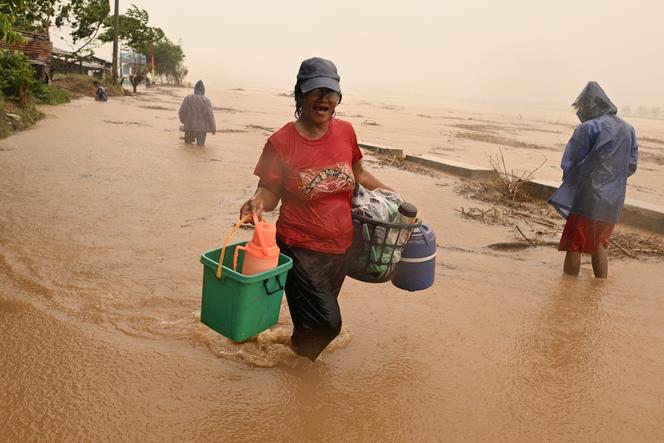 Residents carry their belongings as the river bursts its banks following heavy rains caused by Typhoon Toraji in Ilagan town, Isabela province, November 11, 2024. 