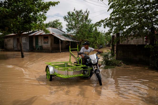 A man on a motorized tricycle on a flooded street following Typhoon Man-yi, in Quezon City, Nueva Ecija, Philippines, November 18, 2024.