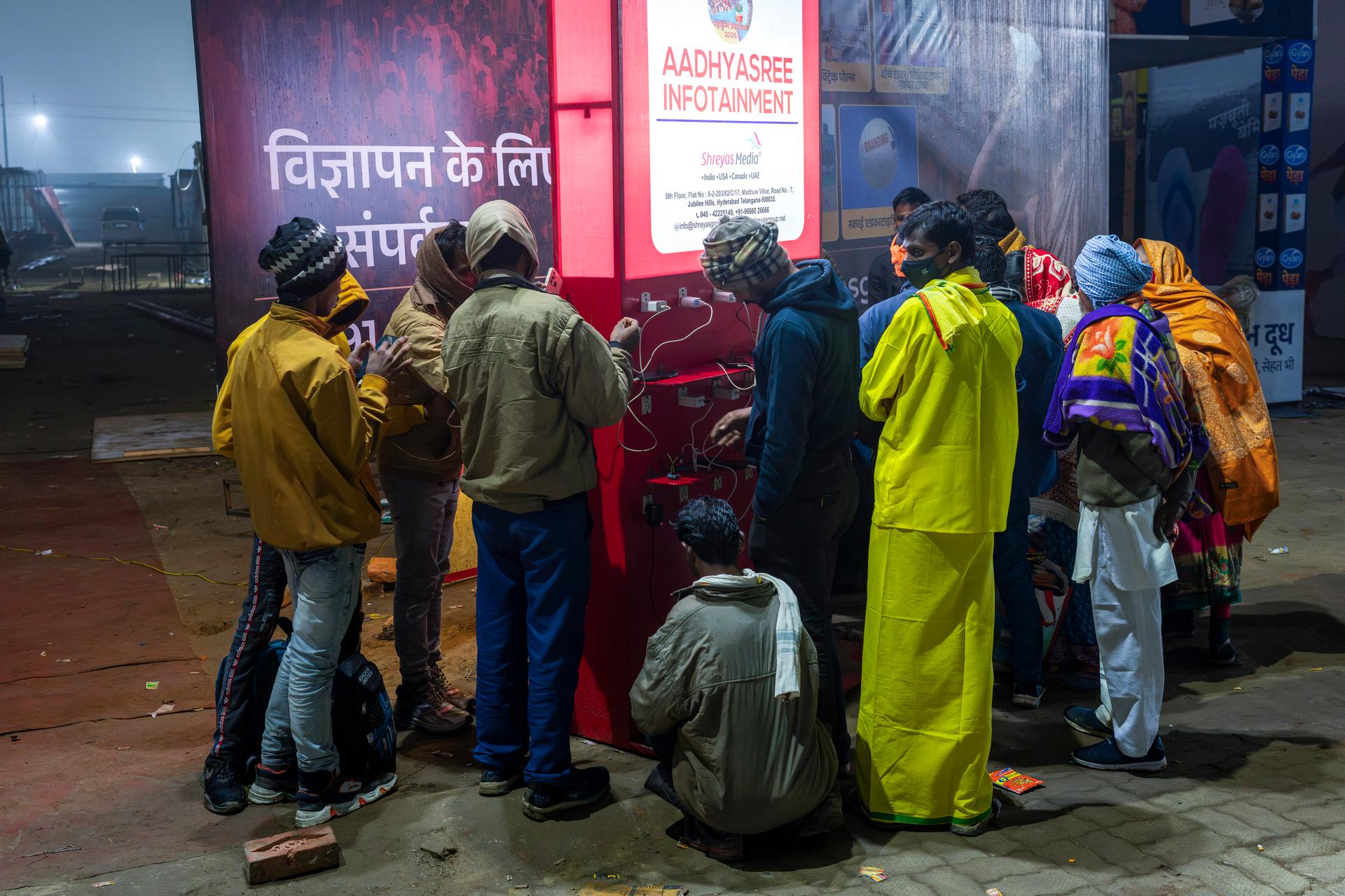 Pilgrims load their phones on a public charging station during the Maha Kumbh festival in Prayagraj, India, January 13, 2025. 